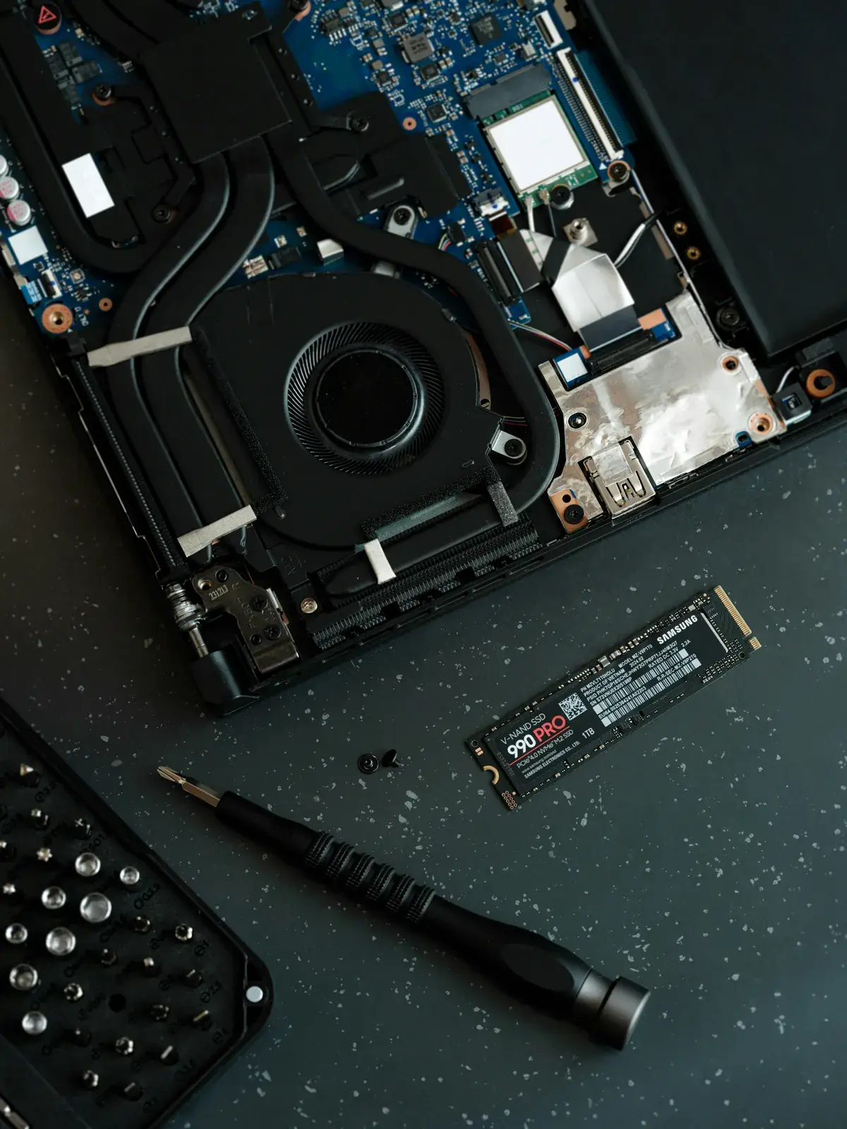 Portable ouvert avec SSD et tournevis lors d’une réparation